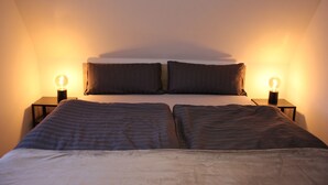 Ein Schlafzimmer mit einem Bett, zwei Nachttischen und zwei Wandlampen.