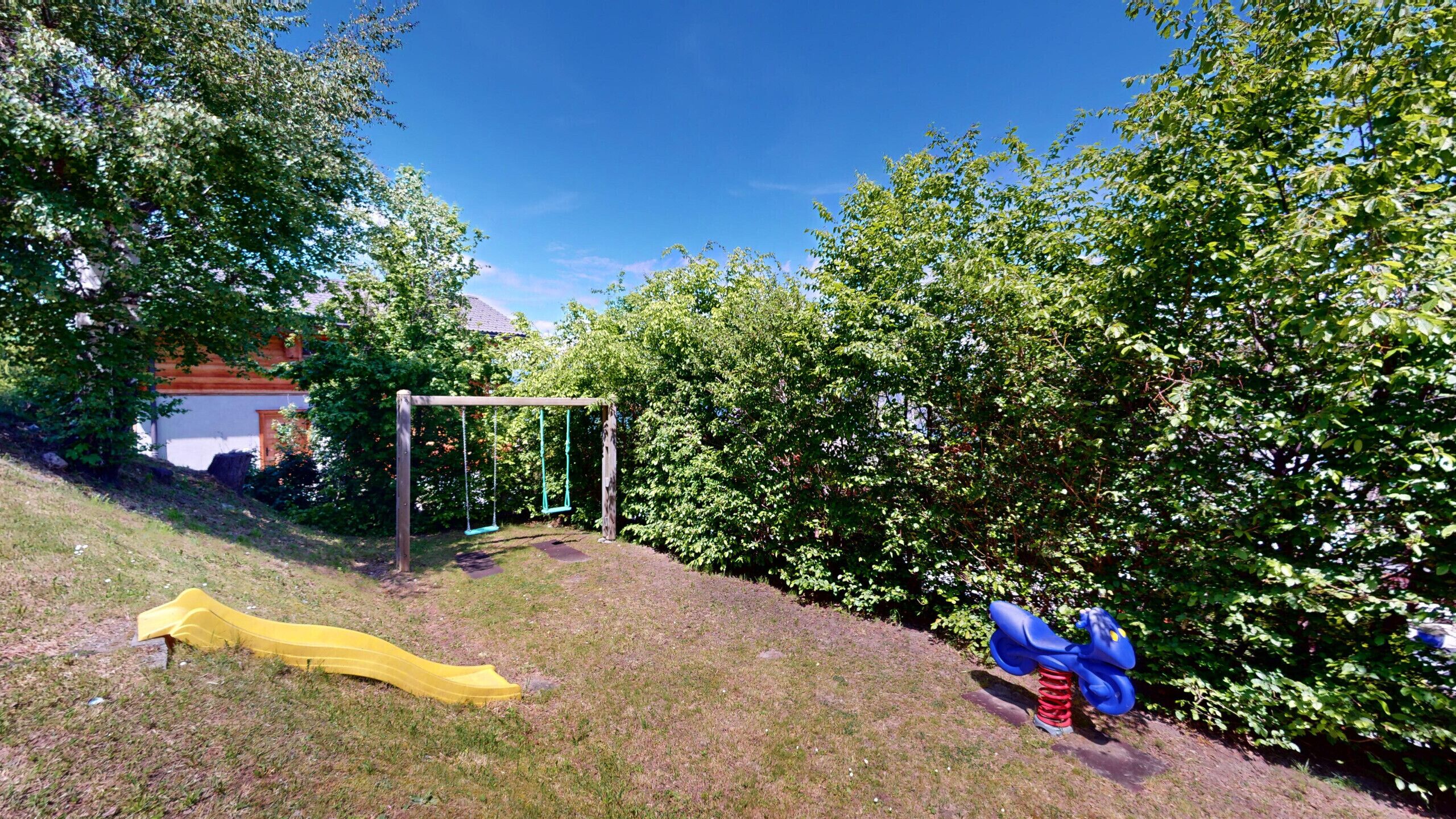 A playground with a swing set, a slide, and a climbing structure.