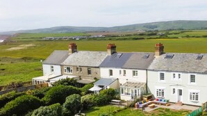 A coastal house with multiple bedrooms, a conservatory, and a garden. - Coastguard Cottage (Atherfield)