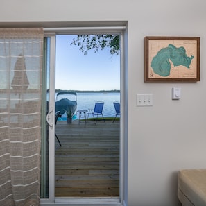 Enjoy a serene lake view from the comfort of your room, with access to an outdoor deck featuring a table and chairs.
