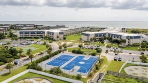 Ein Wohnkomplex mit mehreren Gebäuden, einem Basketballplatz und einem Parkbereich.