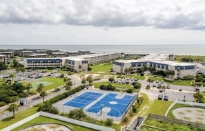 Un ensemble résidentiel comprenant plusieurs immeubles, un terrain de basketball et un espace de stationnement.
