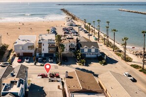 A coastal residential area with multiple-story houses, a beach, and a parking lot. - Ocean just Steps Away! Family and Pet-Friendly (oxnard)