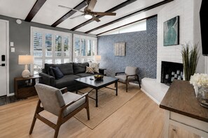 Una sala de estar moderna con sofá, sillones, una mesa de centro y chimenea.