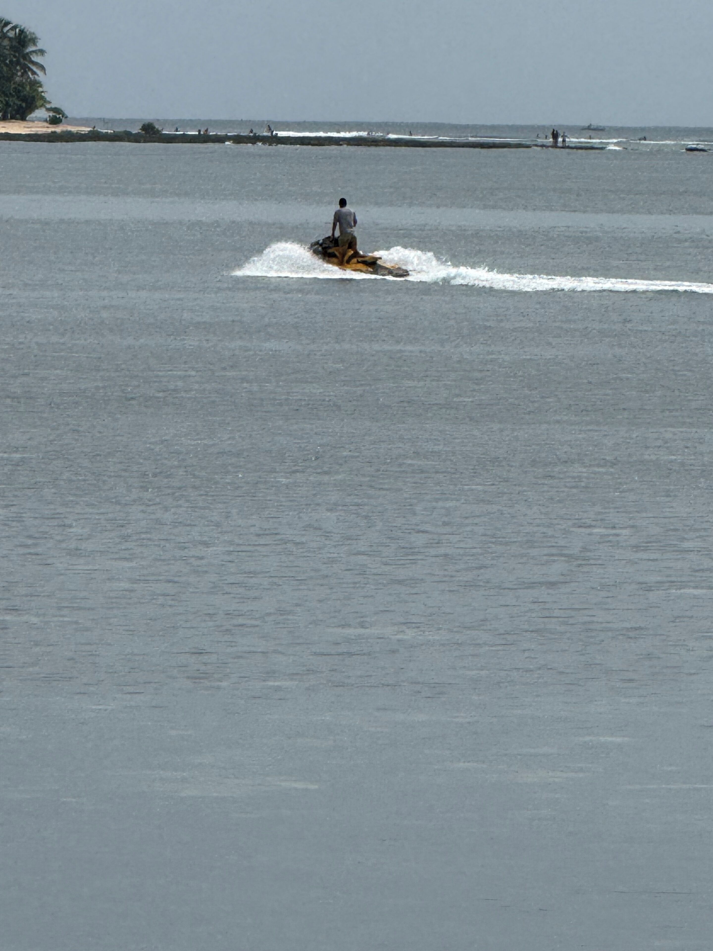 Une étendue d’eau sur laquelle une personne fait du jet-ski.