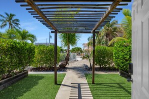 A wooden pergola structure with a pathway leading to a gated entrance. - 1. Key Largo Waterfront Studio | Canal & Ocean (Key Largo)