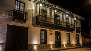 Un bâtiment à deux étages doté d’un balcon, d’une enseigne indiquant « La Xaxa Hotel » et d’une grande porte en bois.