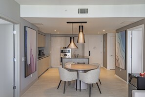 A modern kitchen with a central island, pendant lighting, and a dining area with a round table and chairs. - <br>★★★★★ Hyde Hotel Condo 2BD/2BA Amazing view and excellent RESSORT (Hollywood)