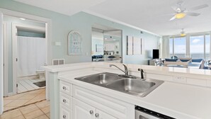 A modern kitchen with white cabinetry, a double sink, and a dishwasher. - Updated 2BR/2BA, 14th Floor, Gulf & Sound Views, Seasonal Beach Service Included (Navarre Beach)