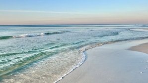 A beach with clear water and gentle waves, a sandy shore, and a clear sky. - Updated 2BR/2BA, 14th Floor, Gulf & Sound Views, Seasonal Beach Service Included (Navarre Beach)