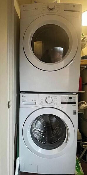 A stacked washer and dryer unit in a laundry room. - Prime World Cup spot! (Seattle)