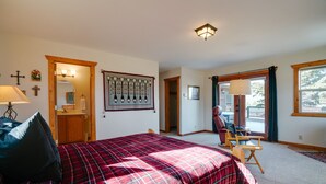 Une chambre à coucher avec un lit, une chaise, une lampe, un crucifix et un tableau encadré au mur.