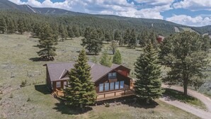 Une cabane entourée d’arbres, située dans une région montagneuse.