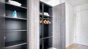 A walk-in closet with open doors, featuring multiple shelves and hanging space. - Sunlit Wiedikon 1 Room w/ Storage & W/D, 1 min to Market, by Blueground (Zurich)