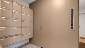 Een opslagruimte met metalen archiefkasten en een grote beigekleurde deur.