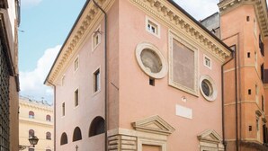 A pink building with arched windows, a circular window, and a door with a pediment. - Ghetto Luxury Design Apartment (Roma)