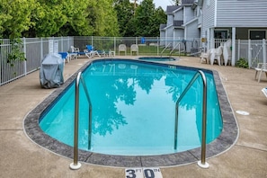 Ein rechteckiger Pool mit 9 Metern Tiefe, umgeben von einem weißen Zaun, mit Liegestühlen und einem überdachten Grillbereich.