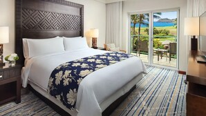 A hotel room with a large bed, a view of the ocean, and a balcony with outdoor seating. - Marriott's Kauai Lagoons 3BR Oceanfront Villa (Lihue)