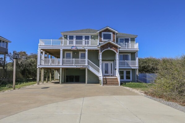 A two-story house with a balcony on the upper floor, a covered entryway, and a garage.