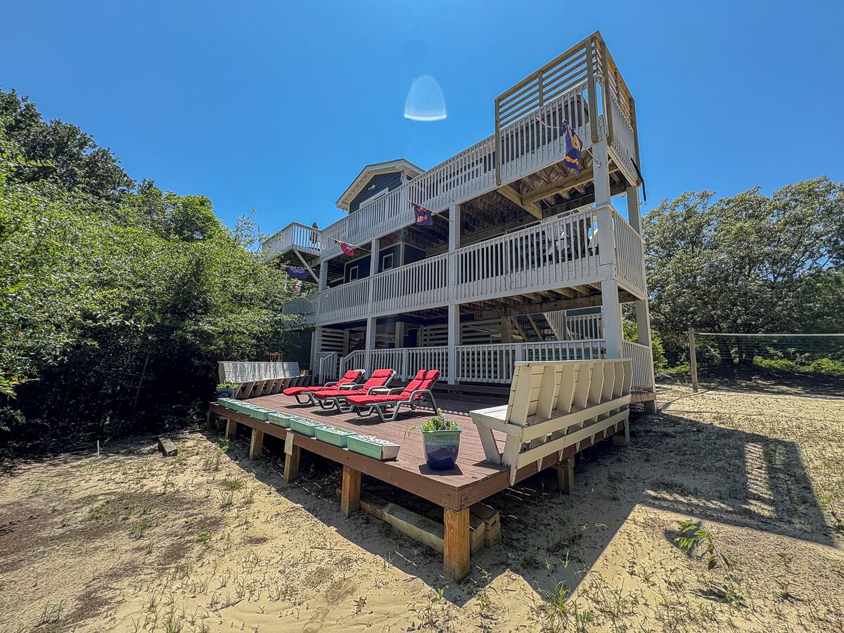 A multi-level wooden structure with outdoor seating and a deck.