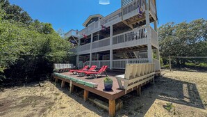 A multi-level wooden structure with outdoor seating and a deck. - Windance - 5 BR Vacation Home on Private Lot w/Pool, Hot Tub, Dogs Allowed (Southern Shores)