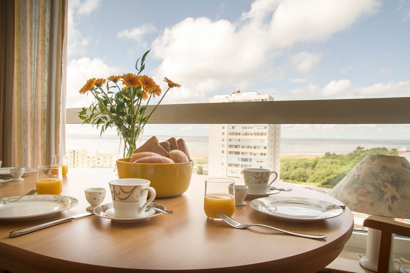 Ett frukostbord med utsikt över en stad och havet.