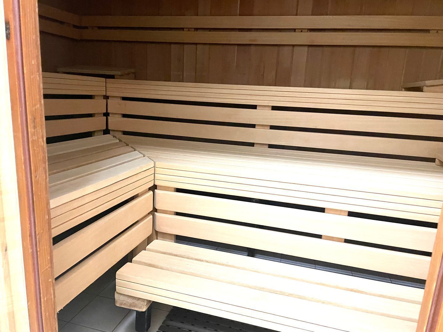 A sauna with wooden benches arranged in a corner.