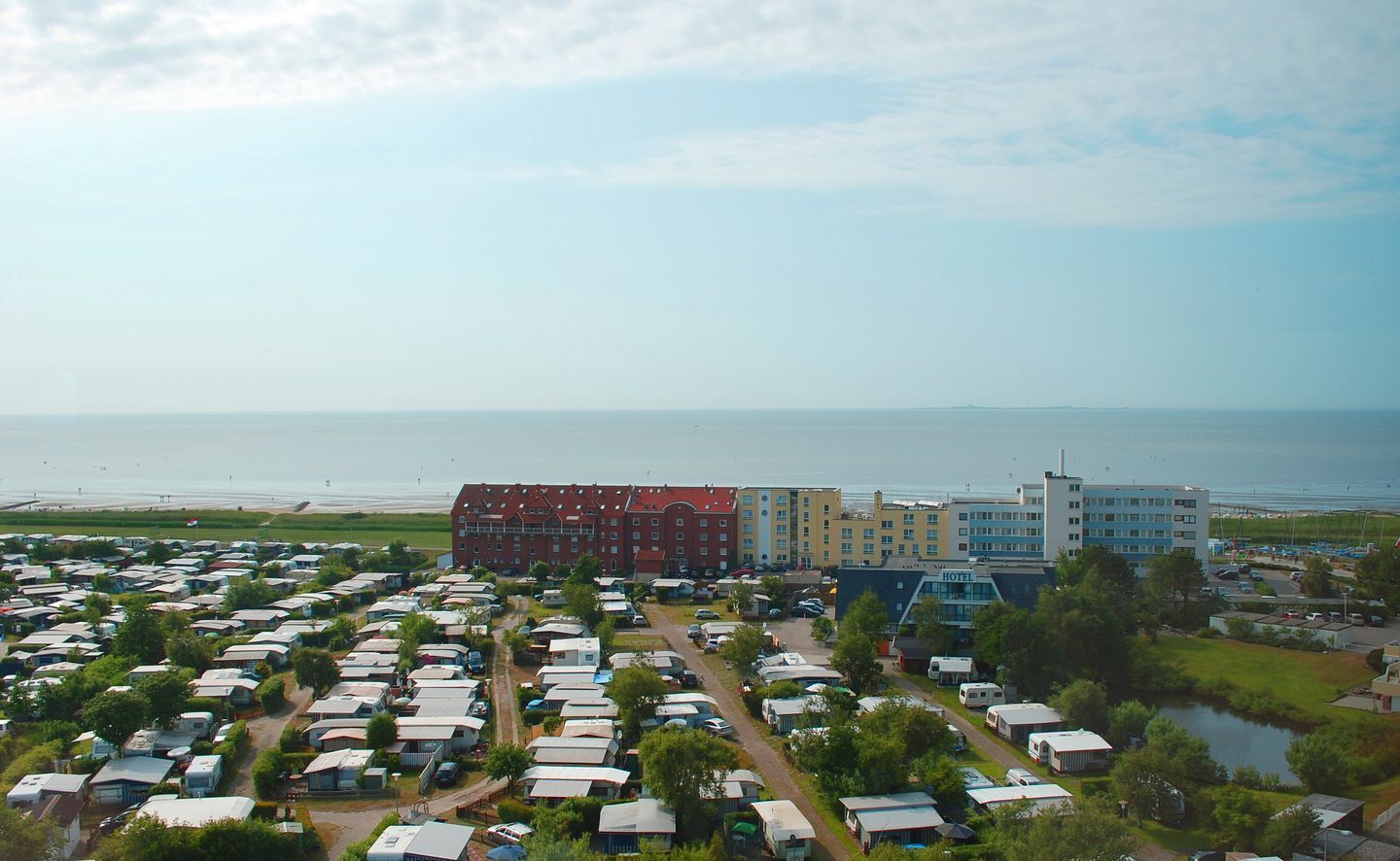 A large RV park with multiple caravan sites and a hotel in the background.