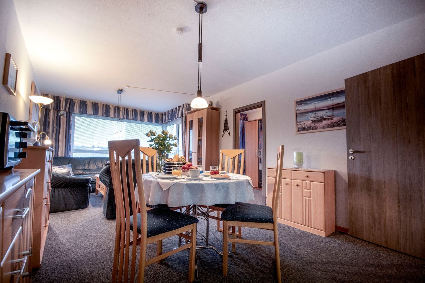 Un espacio habitable compacto con comedor, kitchenette y una zona de estar acogedora.