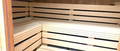 A sauna with wooden benches arranged in a corner.