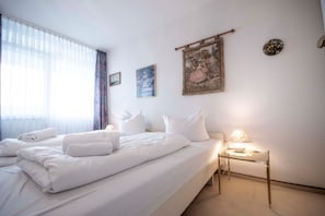 A hotel room with a large bed, a bedside table with a lamp, and artwork on the walls. - FB 12.01 - Liebevoll Eingerichtete Wohnung mit Wunderschönem Meerblick - Frische Brise (Cuxhaven)