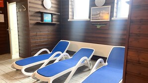 A room with four blue lounge chairs, wooden panel walls, a small shelf with a framed picture, and a door labeled "FOURTH". - Frische Brise, September 2—Newly Renovated Vacation Rental - Haus Frische Brise (Cuxhaven)