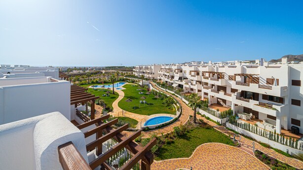 A resort with multiple white buildings, a swimming pool, and a well-maintained garden. - Apartamento El Nido - Mar de Pulpi (San Juan de los terreros)
