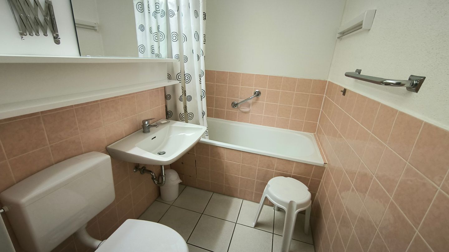 A bathroom with a toilet, sink, and bathtub.