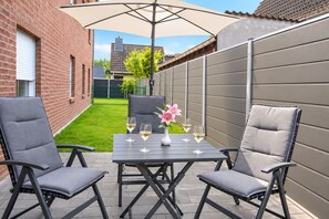 An outdoor patio with a table, four chairs, and an umbrella. - DS2 - Nordic-style vacation rental near the beach for 4 people - House (Cuxhaven)