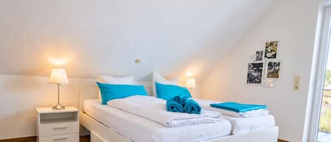 Ein modernes Schlafzimmer mit einem Bett, Nachttischen und einem Fenster.