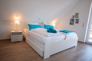 A modern bedroom with a large bed, two bedside tables, and a nightstand.