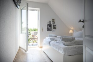 Quarto com cama, porta e vista para o exterior.