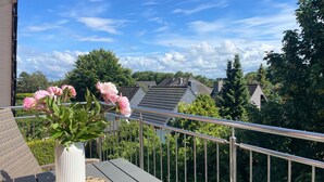 Ein Balkon mit Blumentopf und Tisch.