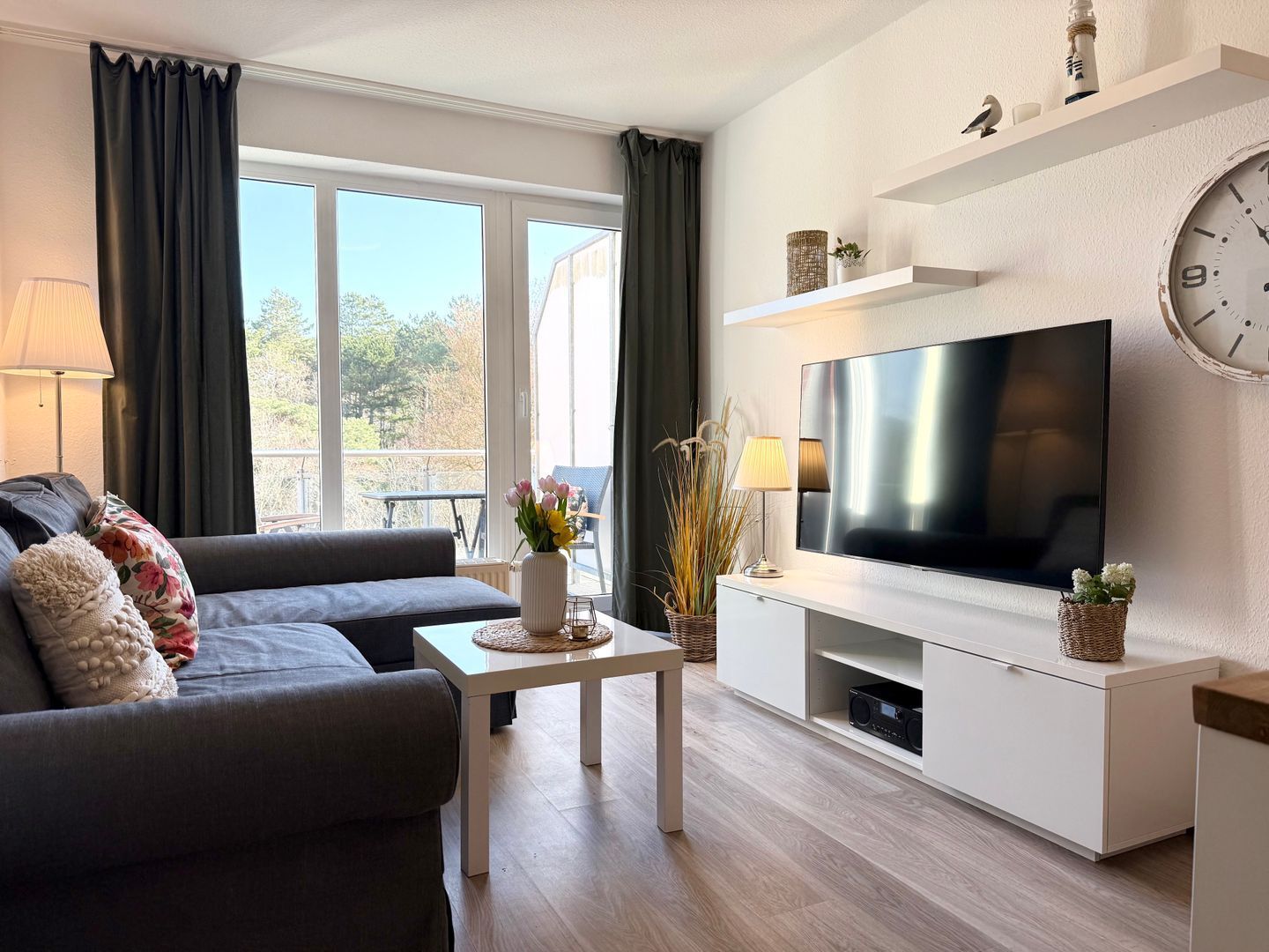 A modern living room with a sofa, coffee table, TV, and decorative items.