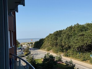 A residential area with a road, a pedestrian crossing, and a view of the sea. - A3.1 - Modern and cozy apartment near the beach for 6 people - House (Cuxhaven)