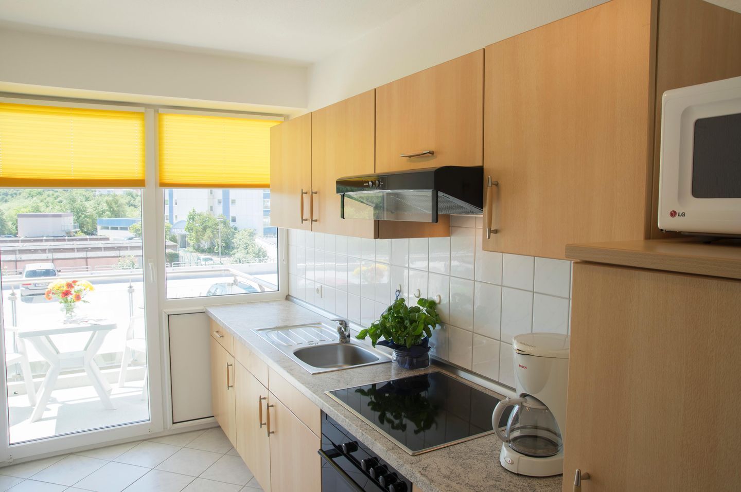 Una cocina moderna con armarios de madera, una estufa negra, un fregadero y un microondas.