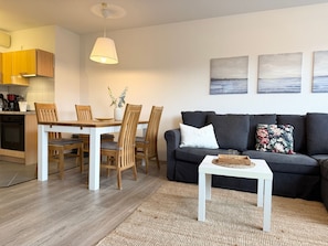Ein modernes Wohnzimmer mit Essbereich, einer Couch und einem Couchtisch.