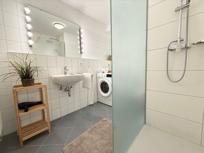 Une salle de bain moderne avec un lavabo, un miroir et une douche.