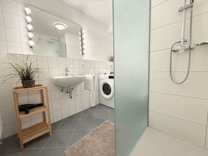 Une salle de bain moderne avec un lavabo, un miroir et une douche.