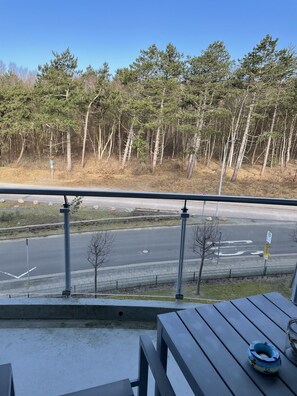 A balcony with a view of a road and trees.