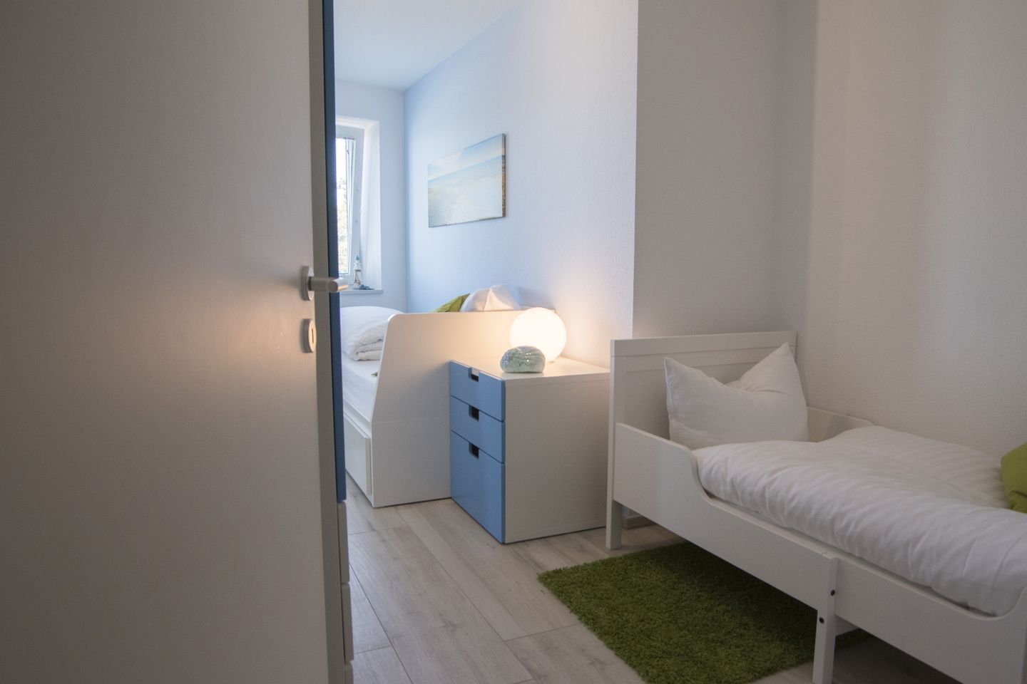 Une chambre à coucher avec un lit, une table de chevet, une lampe et un tableau au mur.