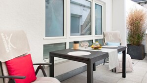 Un patio con dos mesas, sillas y una planta en maceta.