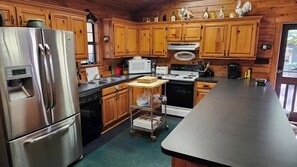Enjoy cooking in this well-equipped kitchen with a refrigerator, dishwasher, microwave, oven, and coffee maker.