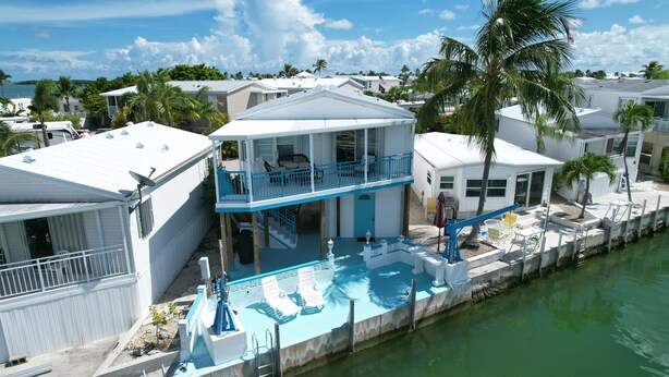A waterfront property with a pool, a balcony, and a view of the sea. - Relaxing Waterfront Escape Near Key West - Venture Out Unit 410 (Cudjoe Key)